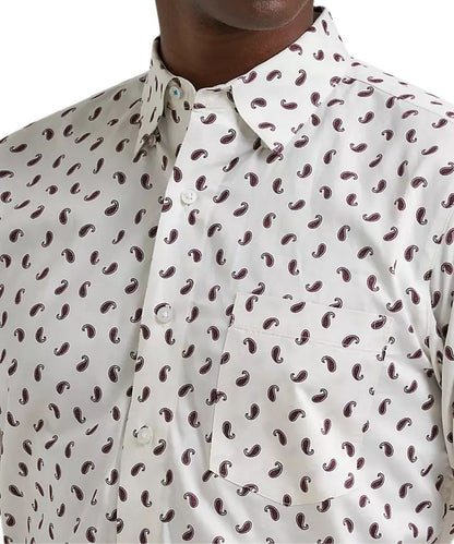 Close-up of a men's button-down shirt with a white base and an all-over dark brown paisley pattern, worn by a model.