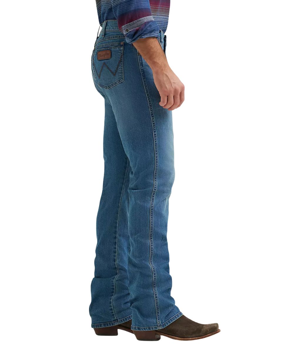 Side view of the men's retro relaxed boot cut jean featuring the mid rise and dark wash