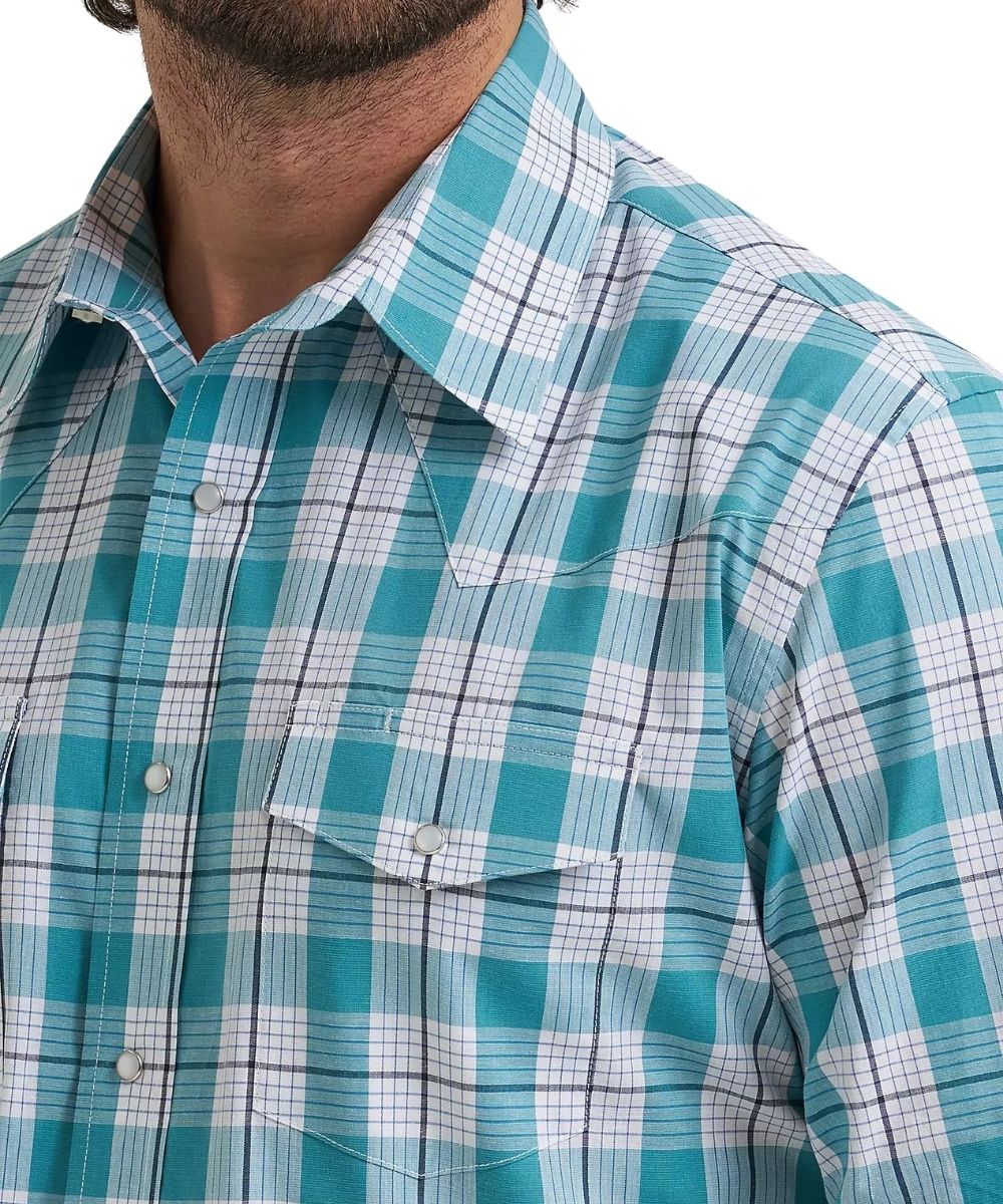 A close-up of a man wearing a teal, white, and black plaid western-style button-down shirt.