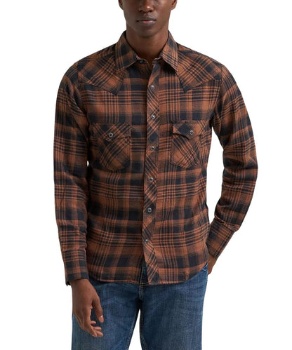 A man wearing a brown and black plaid western-style button-down shirt with two chest pockets, paired with blue jeans, against a plain white background.