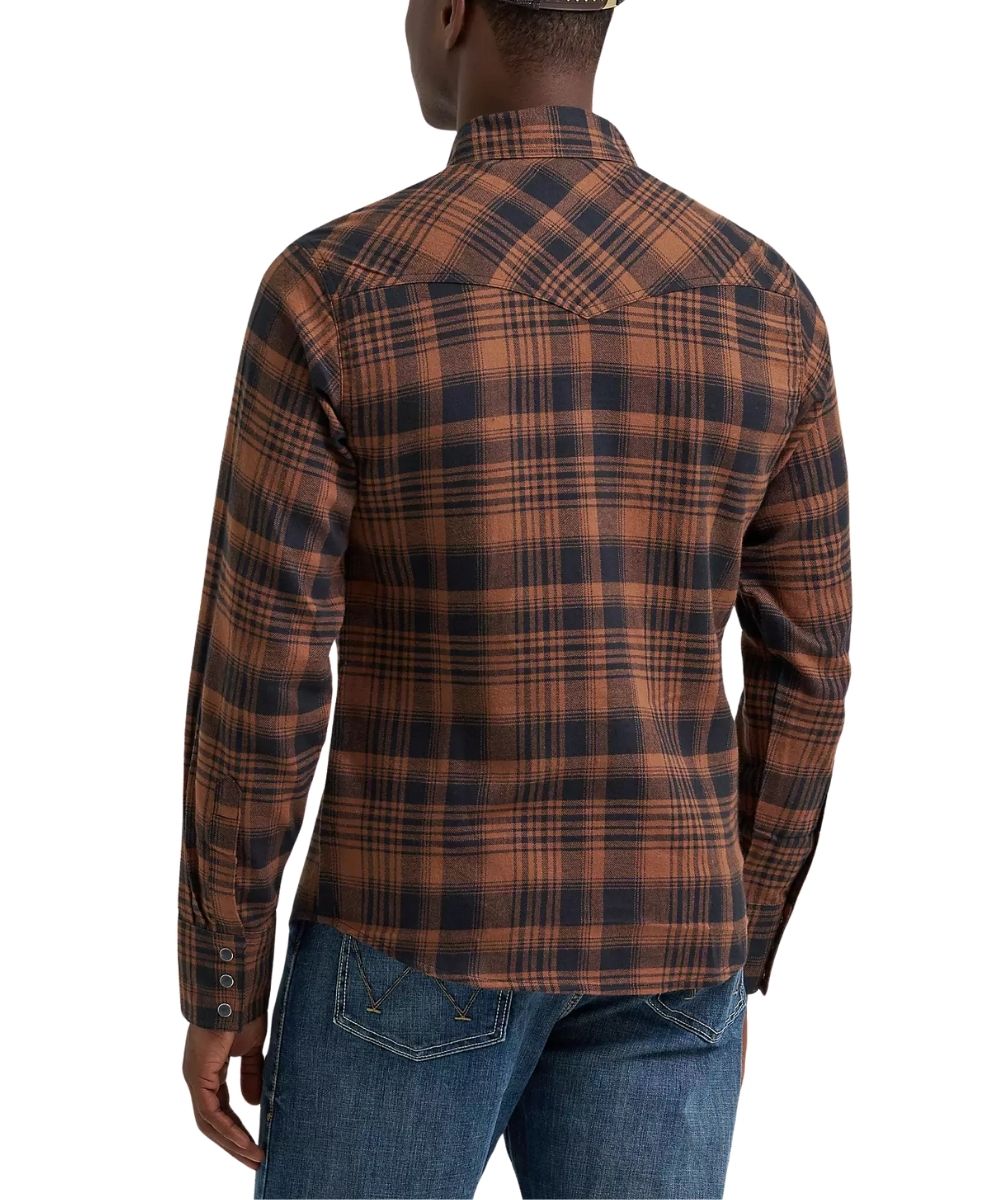 A man viewed from the back wearing a brown and black plaid long-sleeve shirt with western-style stitching, paired with blue jeans, against a plain white background.