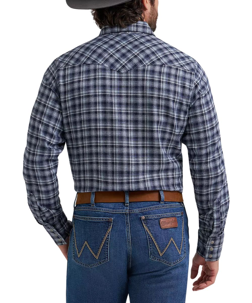 Rear view of a man wearing a long-sleeve plaid western shirt and blue jeans against a white studio background.