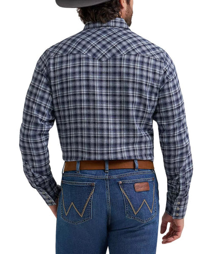 Rear view of a man wearing a long-sleeve plaid western shirt and blue jeans against a white studio background.