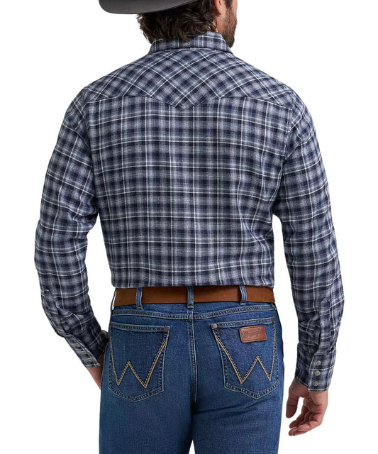 Rear view of a man wearing a long-sleeve plaid western shirt and blue jeans against a white studio background.