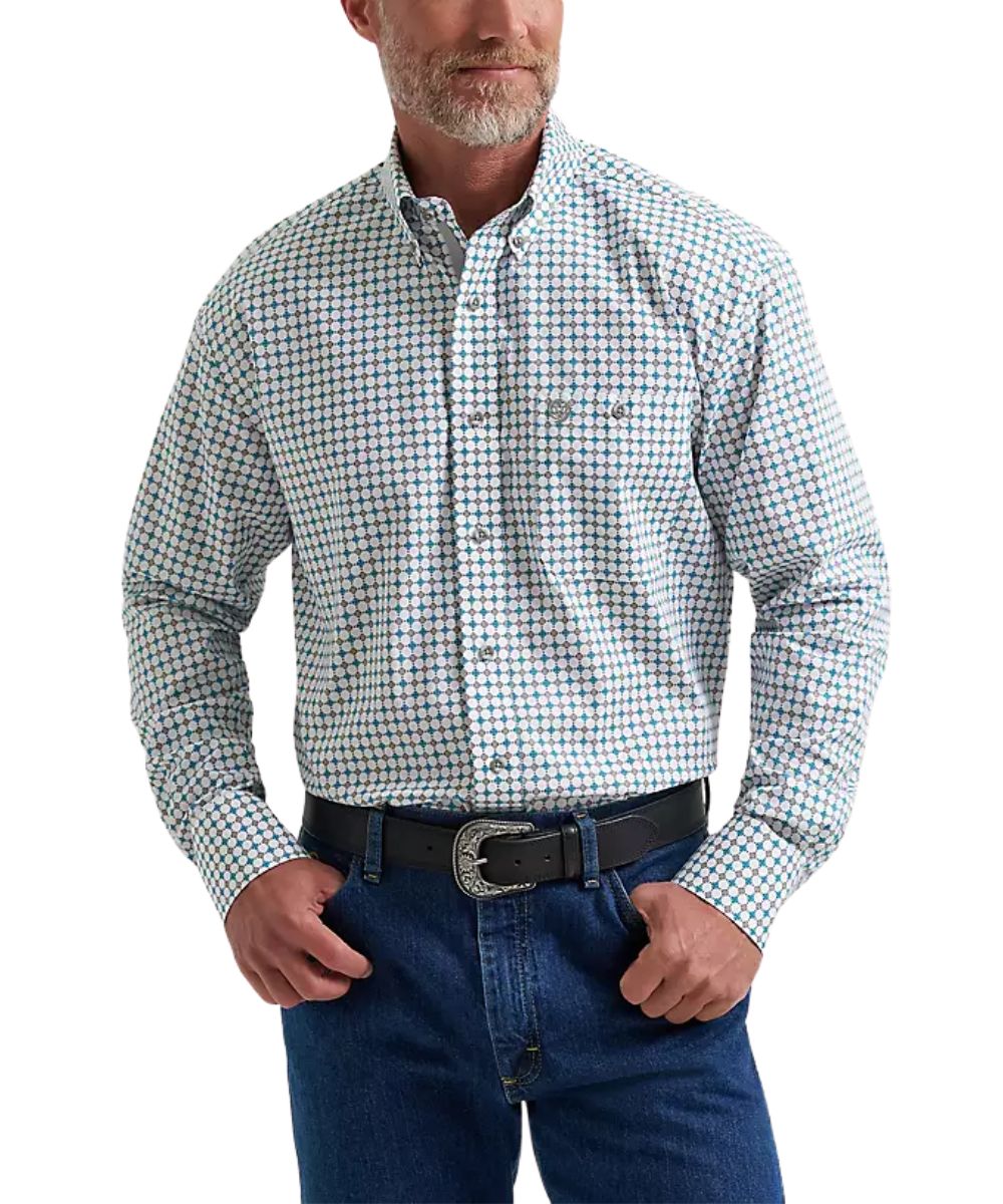 A man wearing a long-sleeve button-down western shirt with a small blue and white checkered pattern, paired with blue jeans and a black belt.