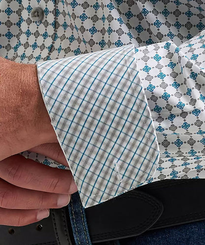 Close-up of a man wearing a long-sleeve button-down shirt with a white, blue, and gray geometric pattern.