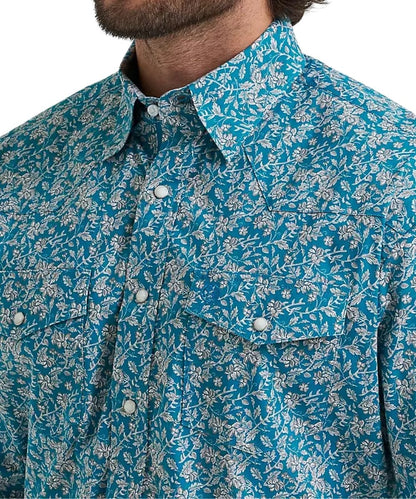 A close-up of a man wearing a short-sleeve button-up shirt with a vibrant blue and white floral pattern.