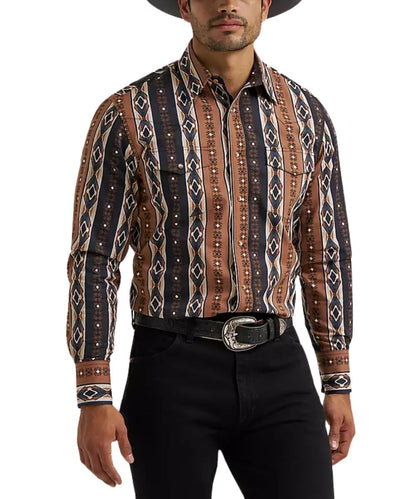 A man wearing a long-sleeve western-style button-up shirt with a brown, black, and beige geometric tribal pattern, paired with black pants and a black hat against a white background.