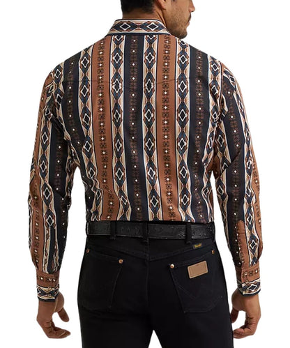 A man viewed from the back wearing a long-sleeve button-up shirt with a brown, black, and beige geometric tribal pattern, paired with black jeans and a black belt.
