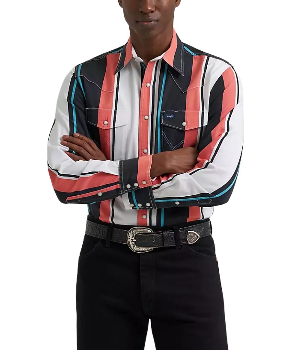 A man wearing a long-sleeve western-style button-up shirt with vertical stripes in black, white, coral pink, and teal, paired with black pants and a black belt with a silver buckle, against a plain white background.