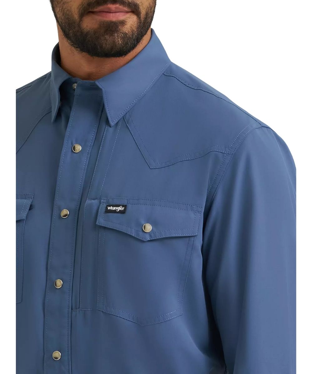 Close-up view of the solid vintage indigo/blue print long sleeve snap shirt featuring the snap flap chest pockets, pen slot, glasses loop, and napoleon pocket
