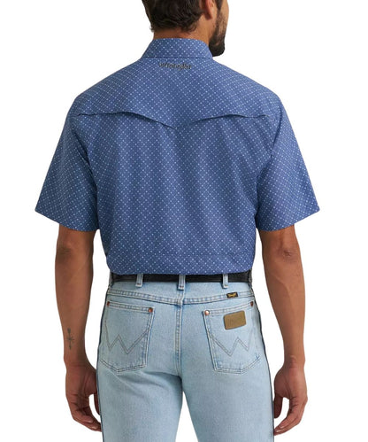 A man viewed from the back wearing a blue short-sleeve western shirt with a small white geometric pattern, paired with light blue jeans.