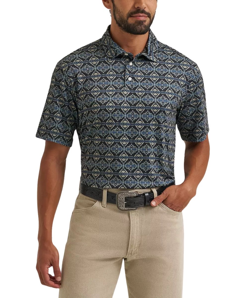 A man wearing a short-sleeve button-up polo shirt with a blue, gray, and beige geometric pattern, paired with khaki pants and a black belt, against a plain white background.