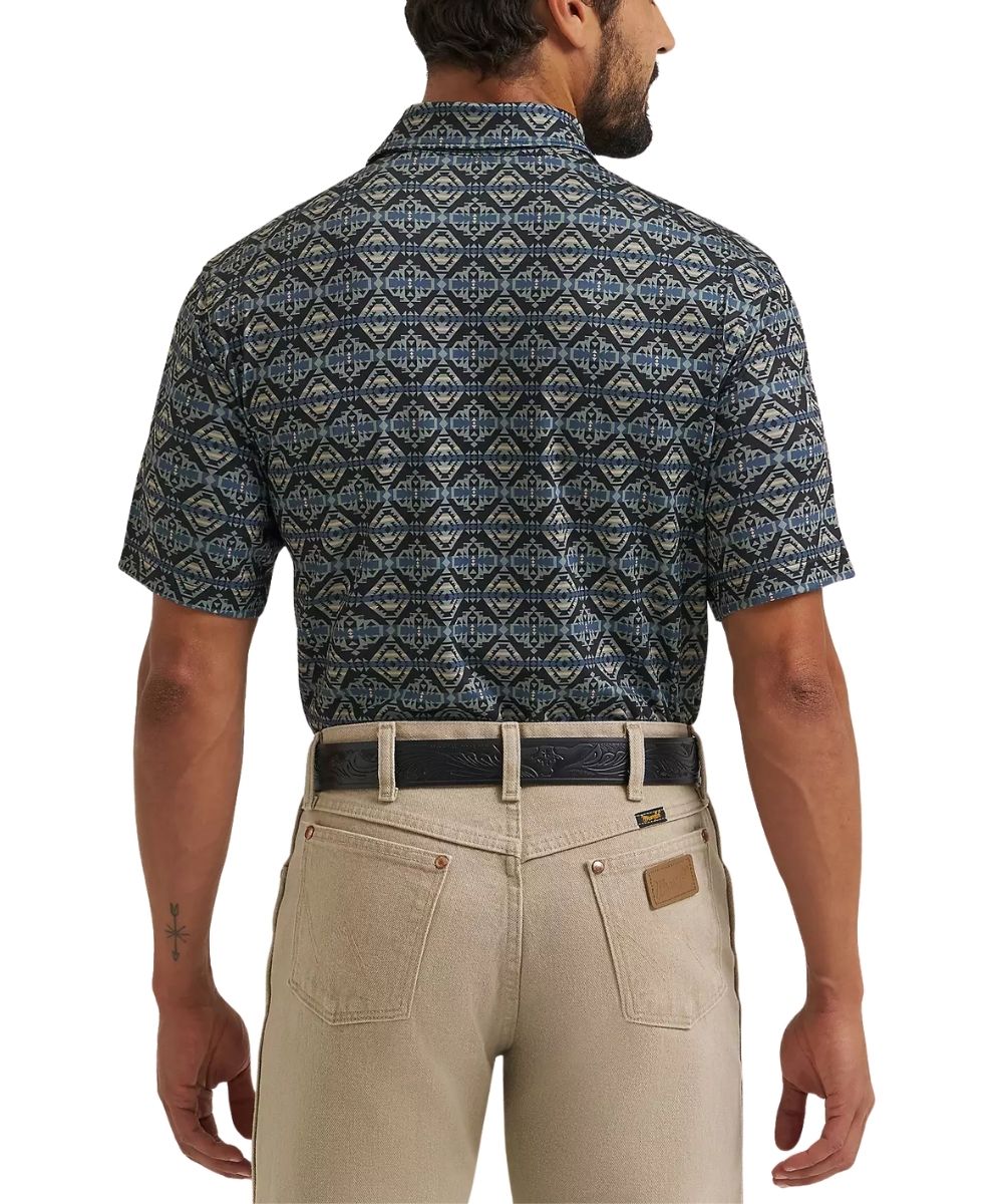 Rear view of a man wearing a short-sleeve button-up shirt with a blue, gray, and beige geometric pattern, paired with beige pants and a black belt, against a white background.