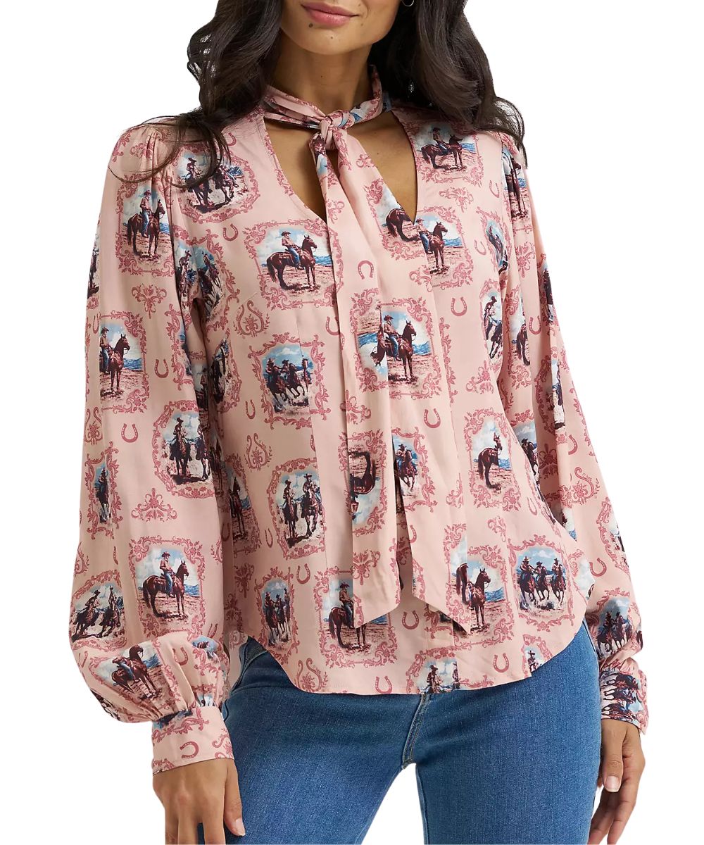 Front view of the women's Wrangler Cameo Tie Neck Blouse in pink featuring the cowboy and horse print, button front closure, and button cuffs