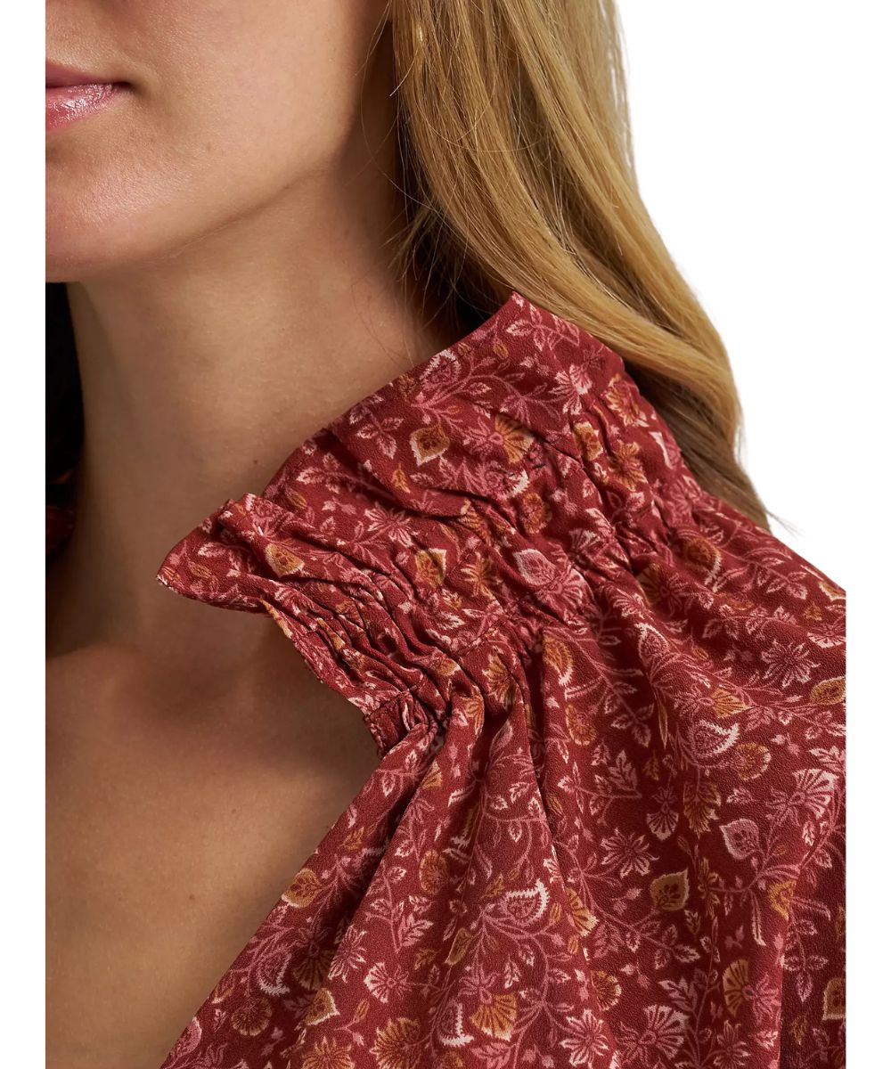Close-up view of the ruffled mock collar featuring a v-neckline