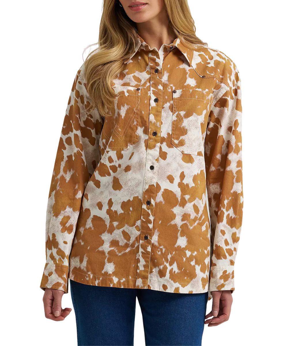 Front view of the women's Wrangler Western Boyfriend Fit Button Down Shirt featuring the oversized fit, oversized chest pockets, and the white and fawn orange cow print