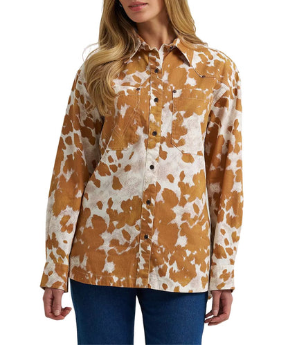 Front view of the women's Wrangler Western Boyfriend Fit Button Down Shirt featuring the oversized fit, oversized chest pockets, and the white and fawn orange cow print