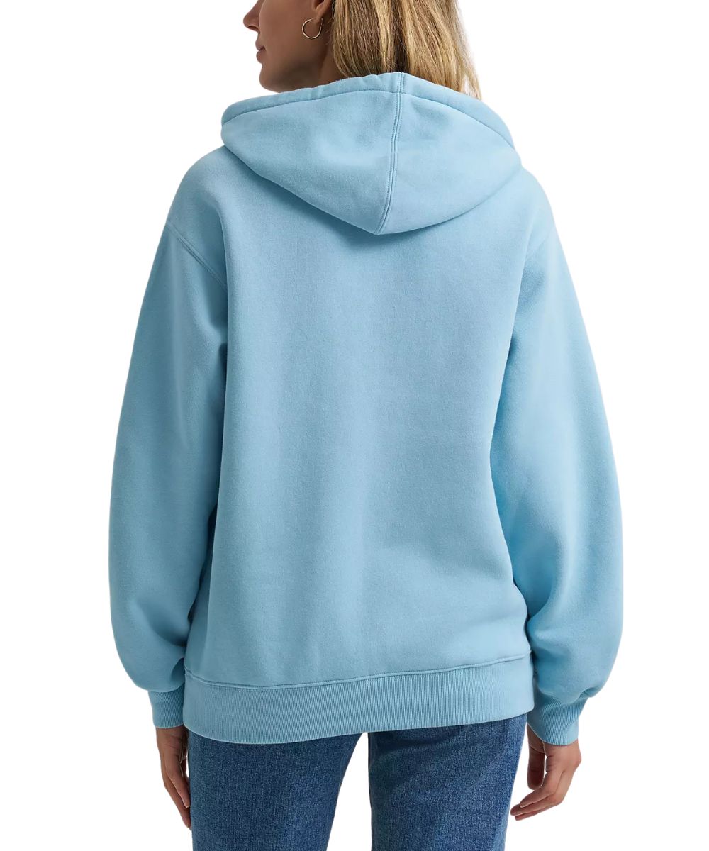 A woman shown from the back wearing a light blue pullover hoodie and blue jeans against a plain white studio background.
