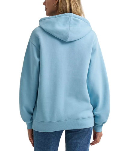 A woman shown from the back wearing a light blue pullover hoodie and blue jeans against a plain white studio background.