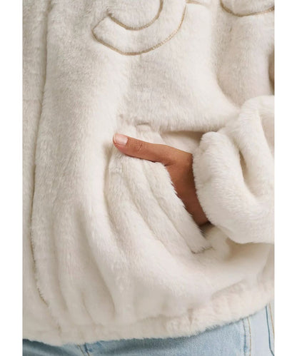 Close-up view of the angled hand pockets and polyester sherpa faux fur