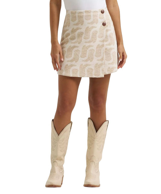 Front view of the women's Wrangler Jacquard Wrap Mini Skirt in white featuring the beige cowgirl boot print