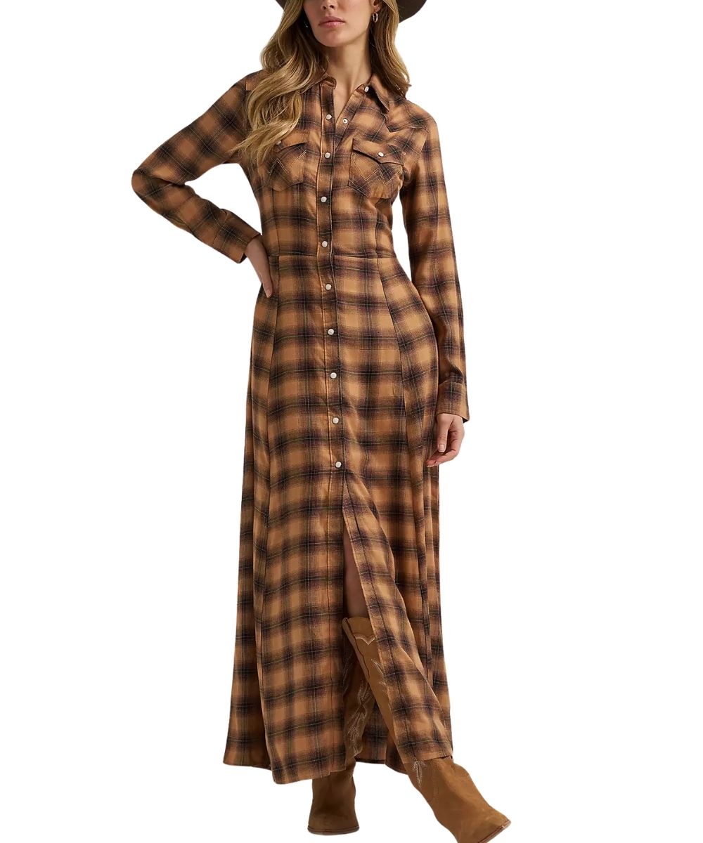 A woman modeling a long-sleeve plaid button-front maxi dress in brown and tan tones, paired with brown boots and a dark hat, against a plain white background.