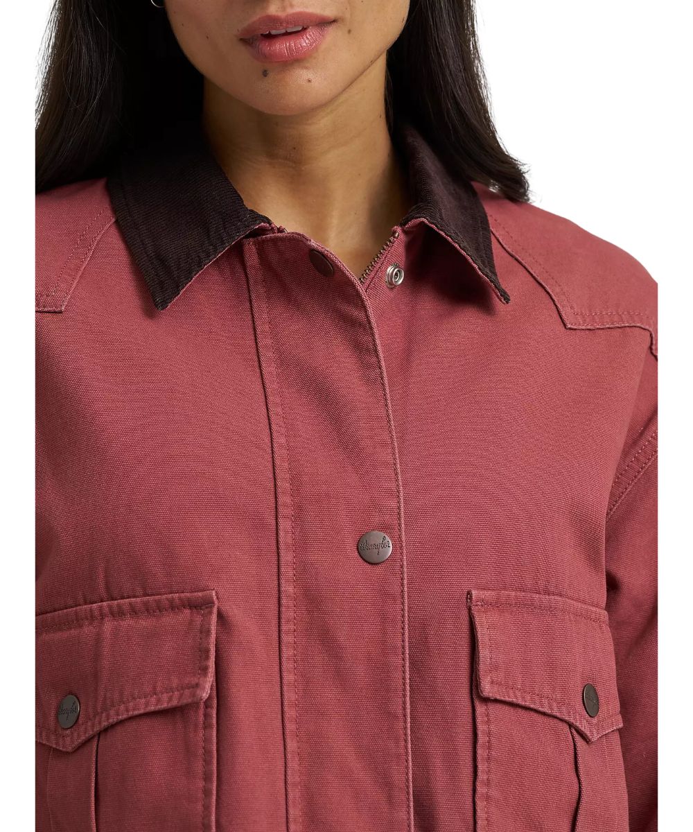 Woman wearing a rose pink jacket with brown corduroy collar and copper snaps