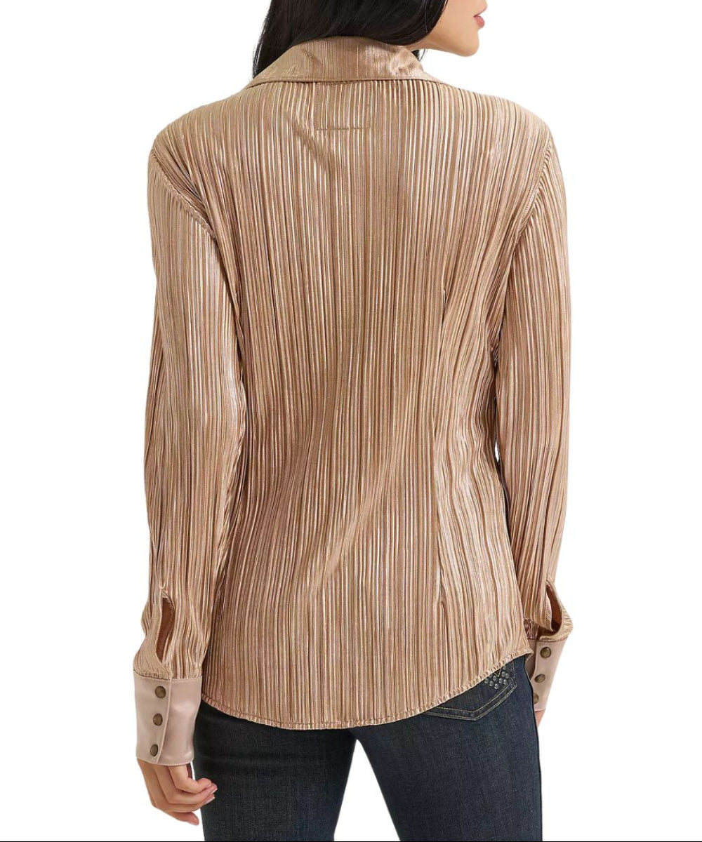 A woman shown from the back wearing a long-sleeve collared blouse with vertical pleats in a warm beige and brown tone, paired with dark jeans against a plain white background.