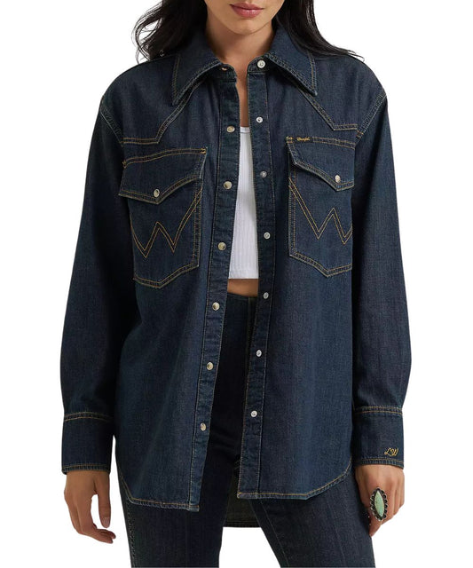 Front view of the women's Wrangler Lainey Wilson Boyfriend Dark Wash Denim Snap Shirt featuring the oversized chest pockets, western yokes, and pearl snaps