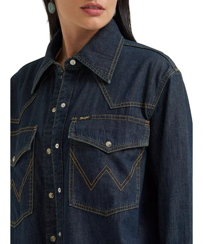 Close-up view of the women's oversized dark wash denim snap shirt featuring the pearl snaps, spread collar, and snap flap chest pockets