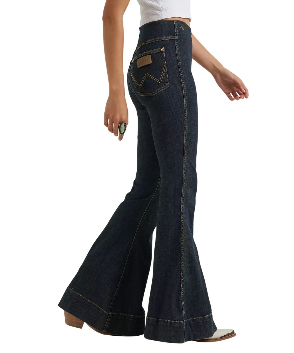 Side view of the women's medium wash sandrider jean featuring the trouser hem and bell bottom flare leg