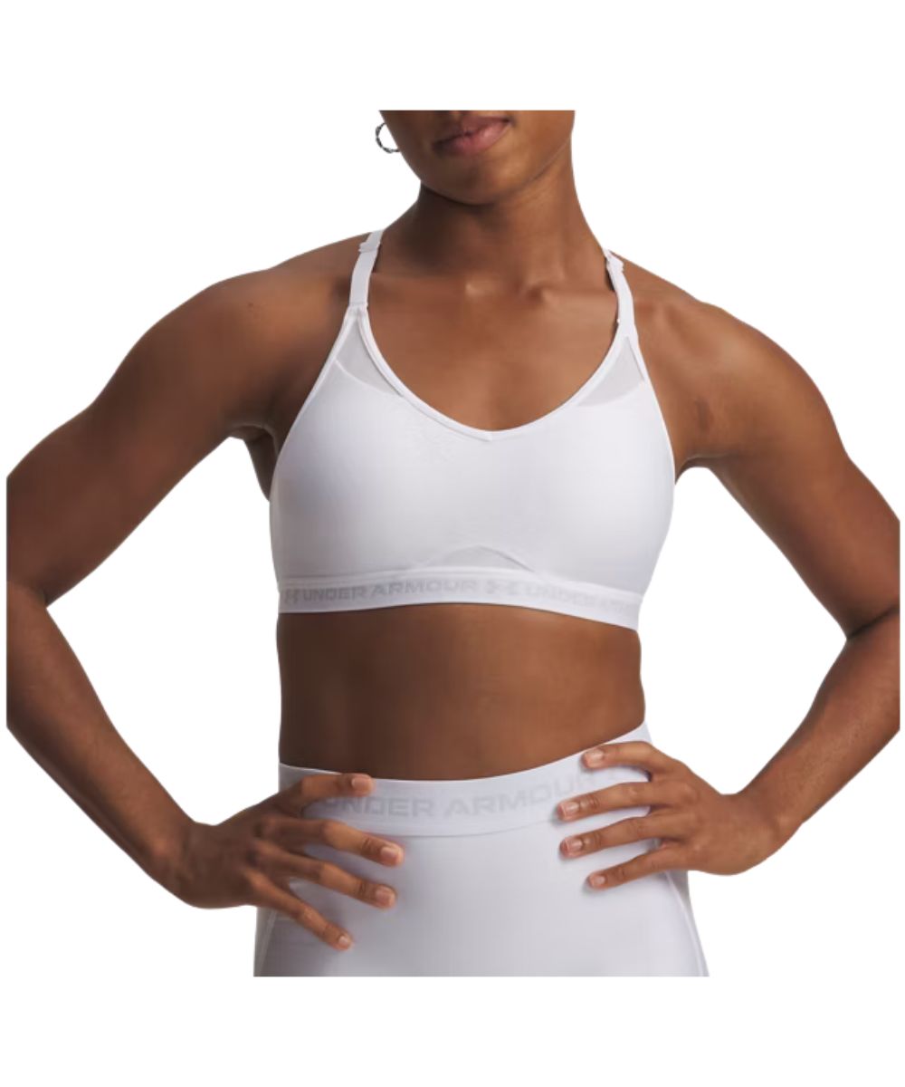 Front view of the women's white Under Armour low sports bra featuring the adjustable spaghetti straps, deep v-neckline, removable padded cups, mesh panels for breathability, and an elastic band with halo gray logo woodmark