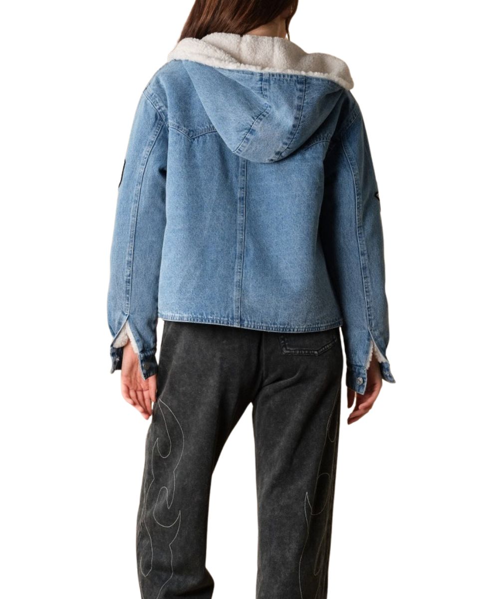 Back view of the women's medium wash denim trucker jacket featuring the hooded collar, double pointed back yoke, and contrast sherpa lining
