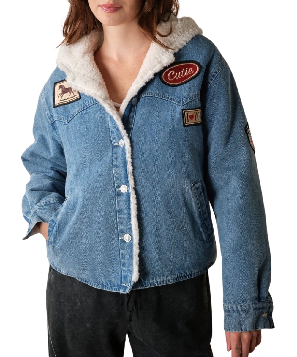 Front view of the women's medium wash Blue B Denim Jacket featuring the sherpa lining, hooded collar, button closure, western yokes, hand pockets, and western patches