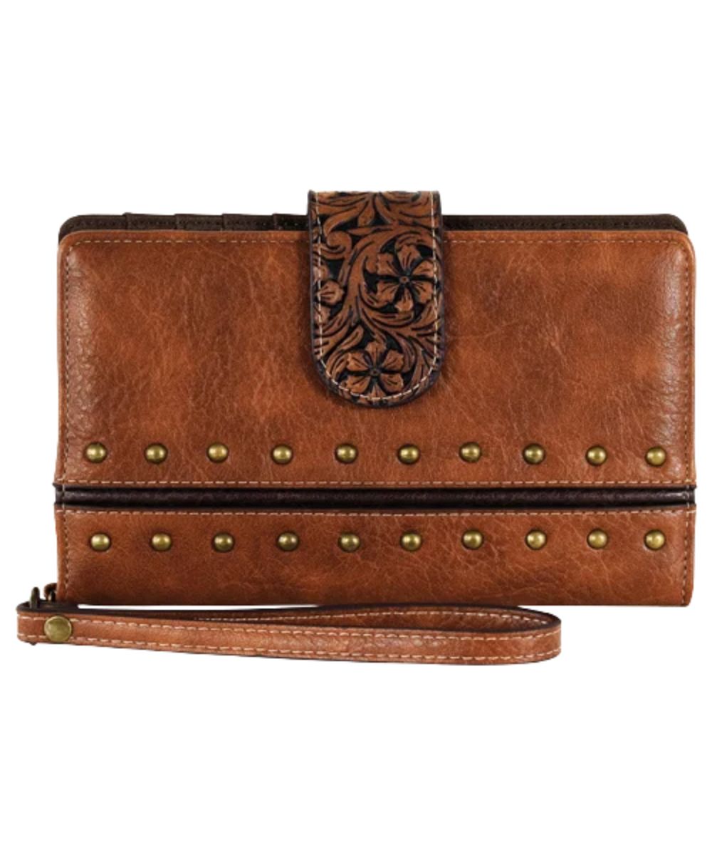 Women's brown leather slim wallet with a removable wristlet strap, brass studs, and a magnetic snap flap closure with floral embossing