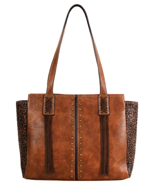 Front view of the women's tan concealed carry tote featuring the brown center seam and floral embossed sides, brass studs, and brown tassels