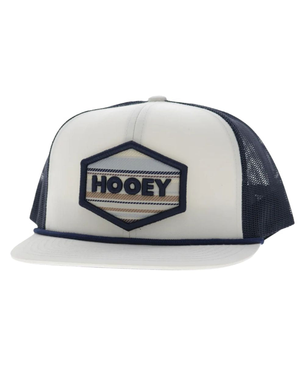 Left angled view of the unisex adult's Hooey Mesa Trucker Snapback Cap featuring the white front with cream and navy hexagon logo embroidery, white hybrid bill with a navy brim rope, and navy mesh sides
