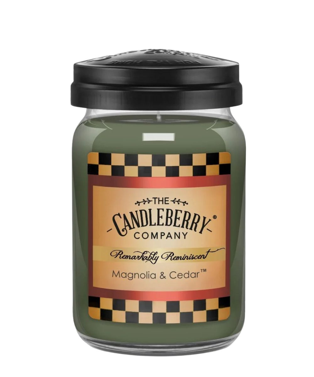 A jar candle from The Candleberry Company, featuring an olive green wax body, a black lid, and a tan label with a black and gold checkerboard pattern, labeled 'Magnolia & Cedar'.