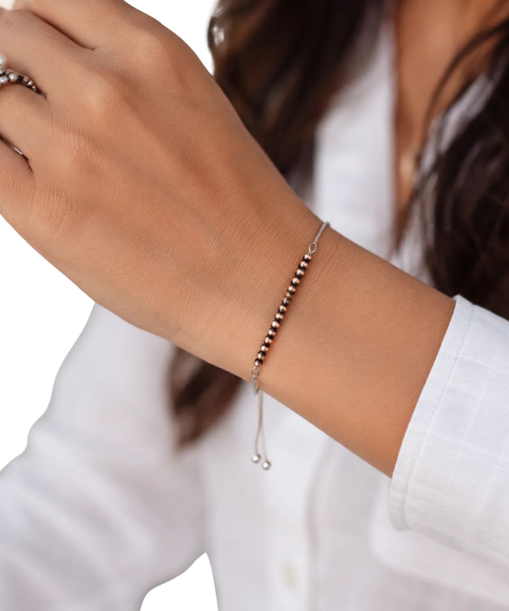 Model view of the women's Isac Trading Copper Western Bead Adjustable Bracelet featuring the brass chain