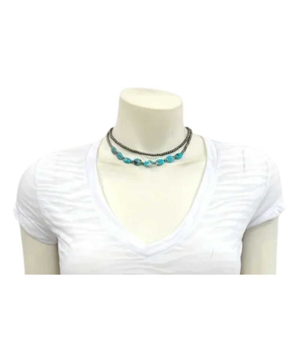 Model view of the women's western Isac Trading beaded necklace featuring the 2 strands, one with tiny 4mm silver faux navajo beads, and the other with faux navajo beads and oval turquoise gemstones