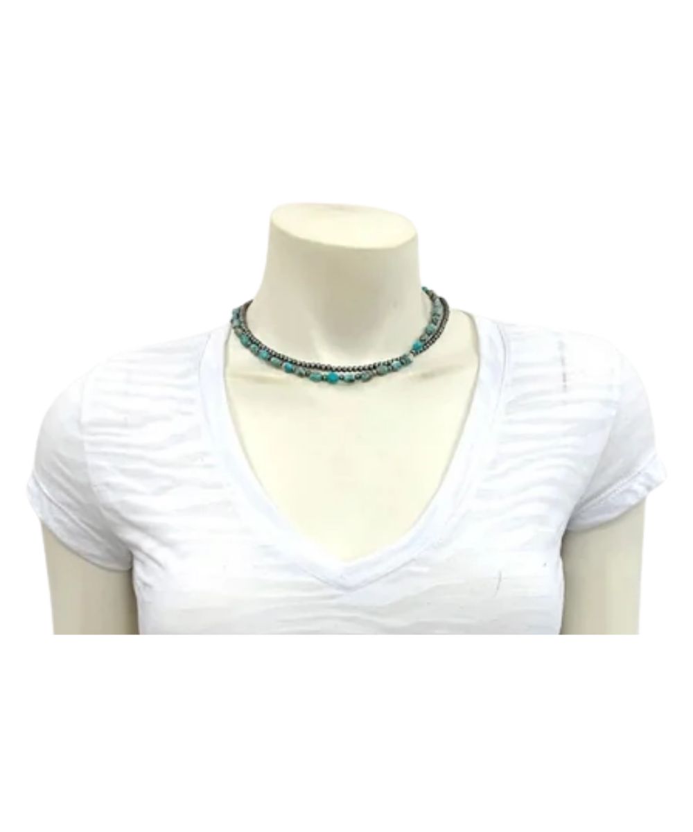 Model view of the women's silver and turquoise double strand Isac Trading western necklace featuring the silver western bead strand and the round turquoise and silver beaded strand