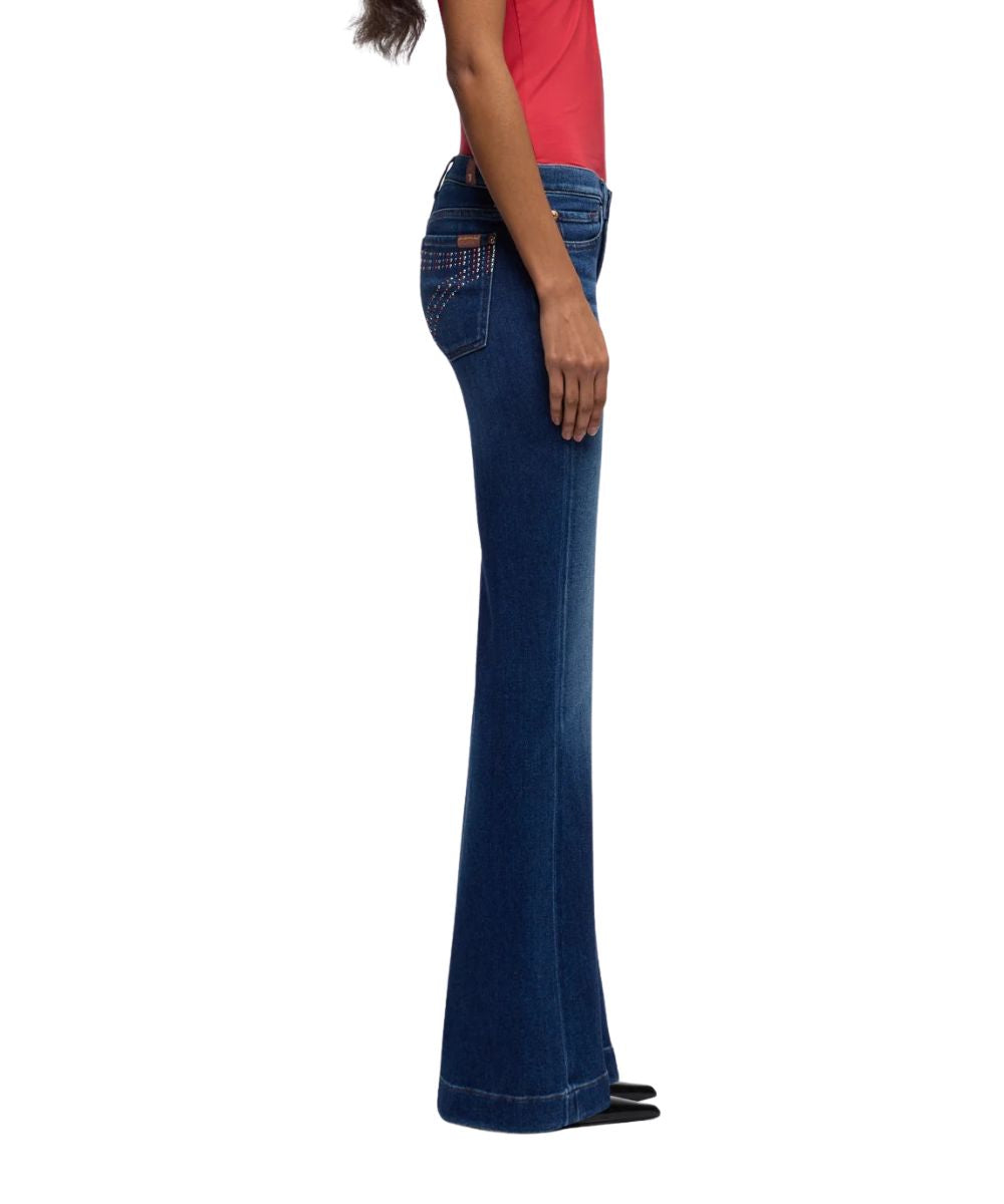 Side view of the women's current dark wash jean featuring a subtle 22" flare leg with a trouser hem, and 34.5" inseam