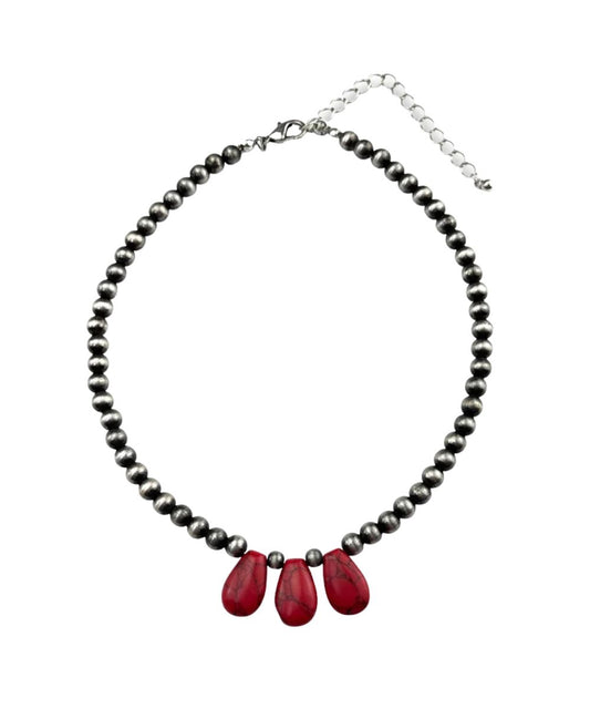 A beaded necklace featuring a strand of small dark gray beads with three prominent red teardrop-shaped beads at the center, finished with a silver-tone lobster clasp and extender chain.