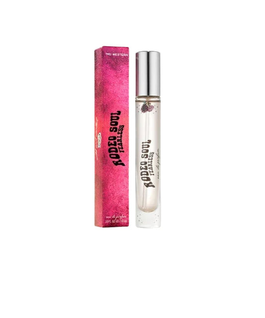 A clear cylindrical rollerball perfume bottle with a silver cap stands next to its bright pink packaging box. The box and bottle are printed with the text 'RODEO SOUL FEARLESS' in black.