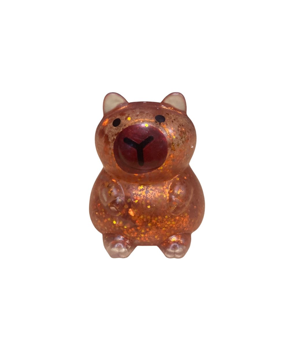 A small capybara glittery stress toy in a translucent amber-brown color, featuring a dark red nose and black eyes, set against a plain white background.