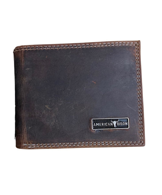 Front view of the men's brown American Bison leather bifold wallet featuring the silver logo plate on the front