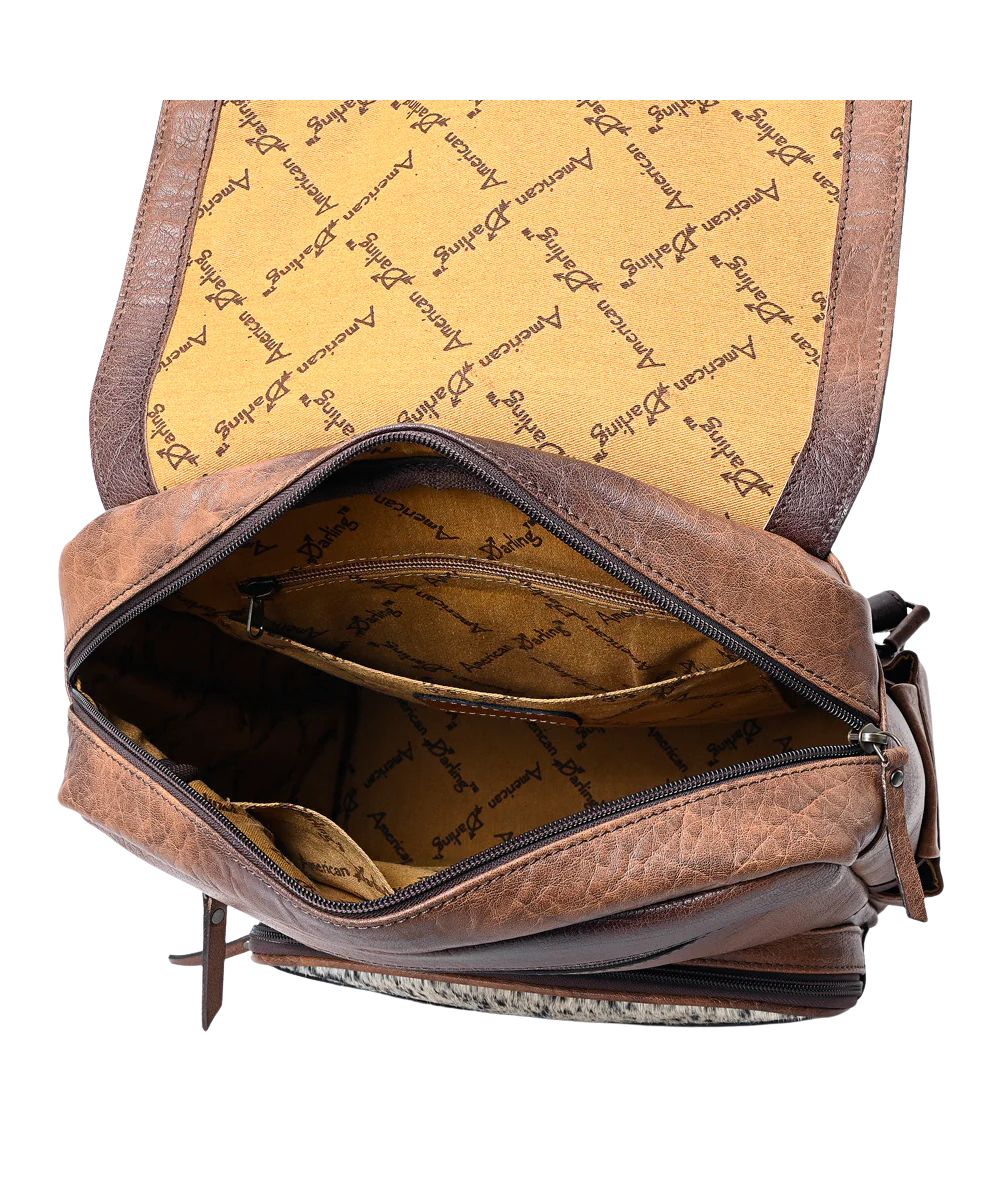 Inside the backpack is a spacious main compartment, with a zipper pocket, and slip pockets accented with the American Darling logo liner.