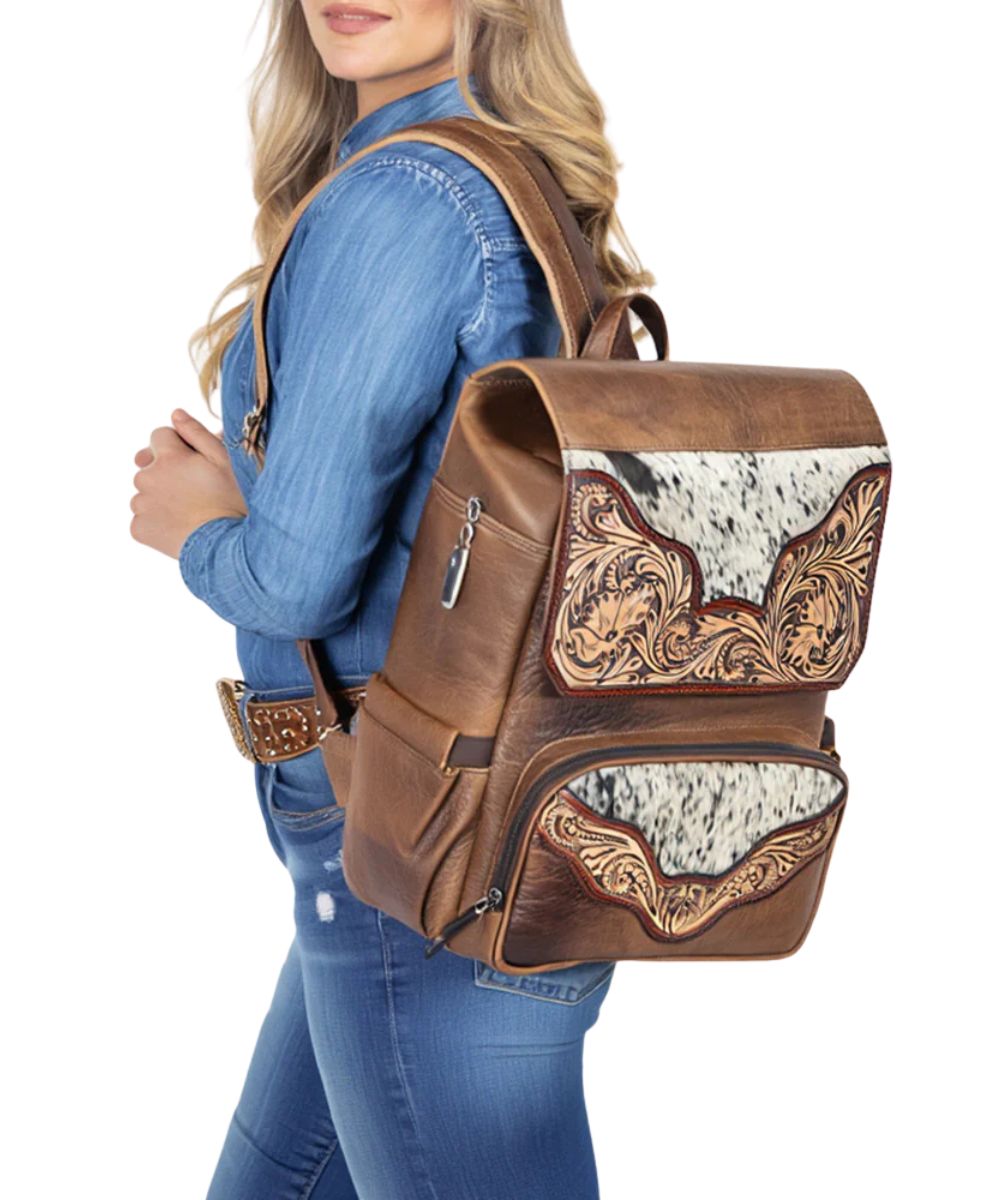 Model showcasing the American Darling cowhide and hand tooled leather backpack, a western travel bag.