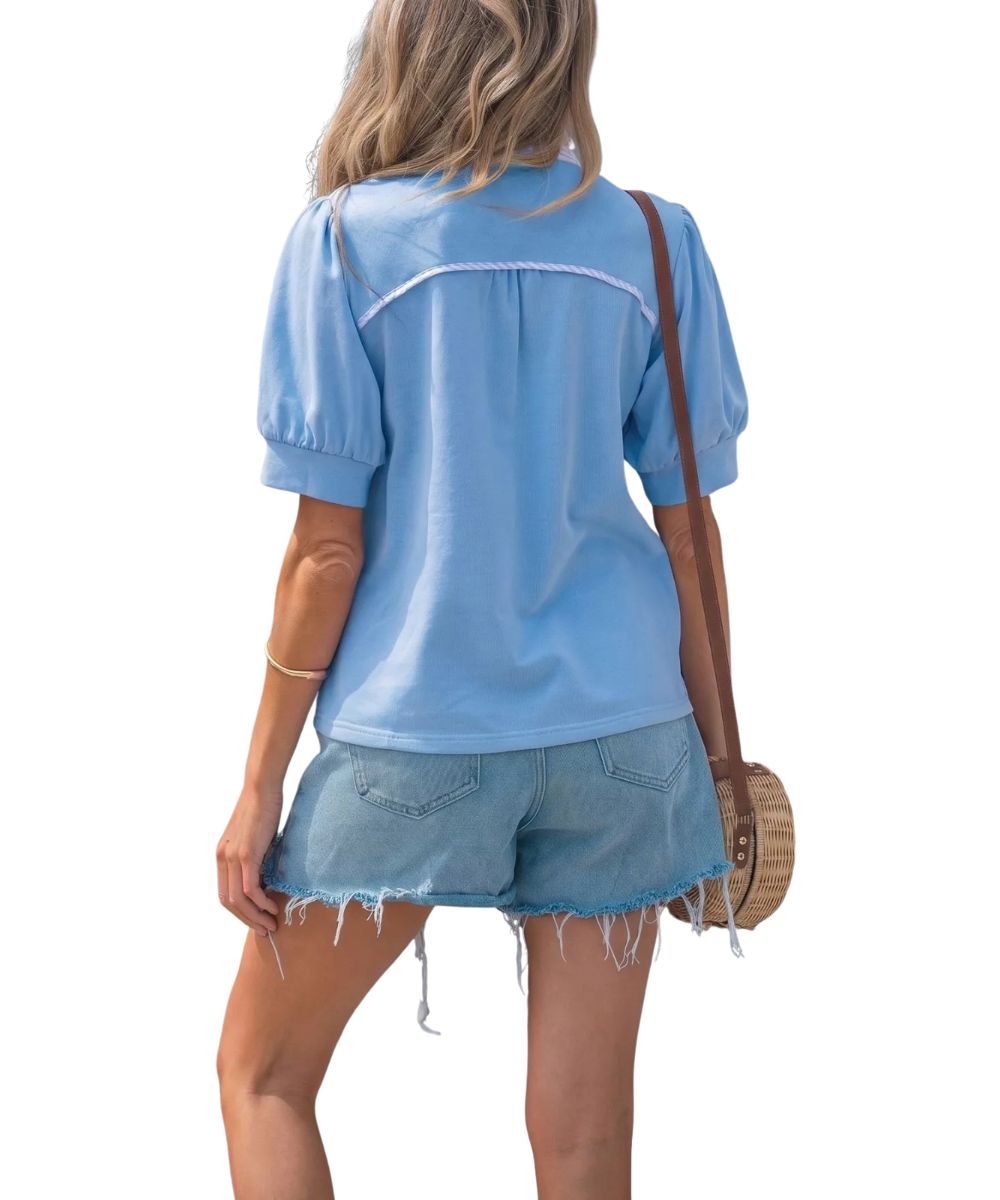 Back view of the women's sky blue blouse featuring the curved back yoke with contrast trim and pleating